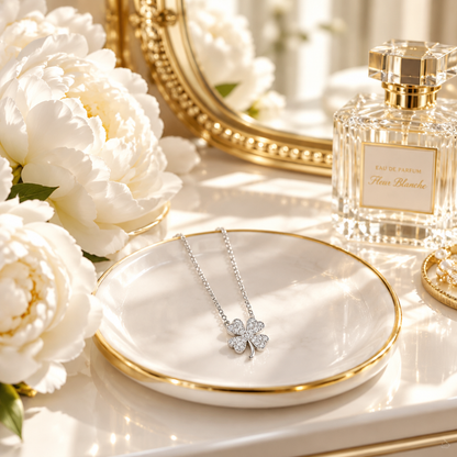Collier trèfle or S999 en scène lifestyle lumineuse – coiffeuse blanche, miroir doré, style chic féminin