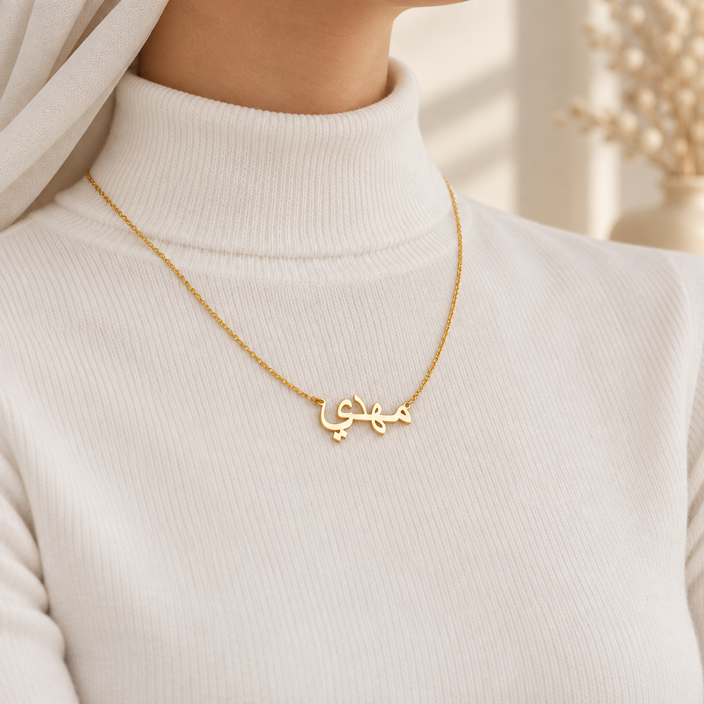 Mockup collier calligraphie arabe or porté, femme habillée jusqu'au cou, visage hors cadre, Kylara