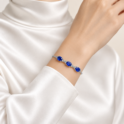 Mockup bracelet tanzanite bleu porté au poignet, femme satin blanc, Kylara