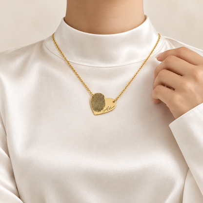 Mockup collier cœur empreinte or porté, femme satin blanc jusqu'au cou, visage hors cadre, Kylara