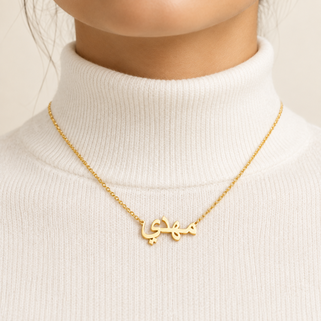 Mockup collier prénom arabe or porté au cou, femme col blanc – Kylara